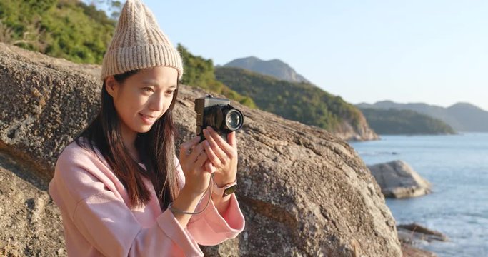 Woman taking photo on camera over seascape background