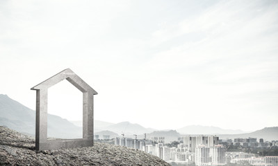 Conceptual image of concrete home sign on hill and natural lands