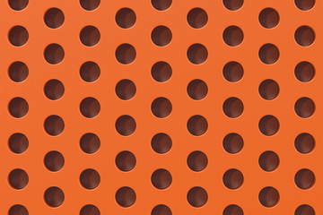 Plain orange surface with cylindrical holes