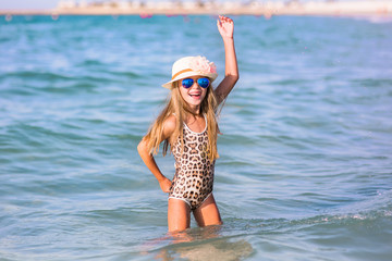 Portrait of a pretty baby girl wearing cute sunglasses on the beach, sweet kid smiling  happy summer vacation