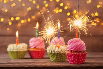 cupcake with sparkler on old wooden background