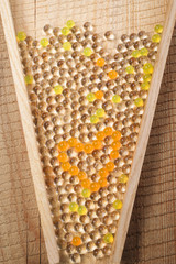 Transparent beads of different colors with a heart shape in a funnel in the form of an hourglass on...