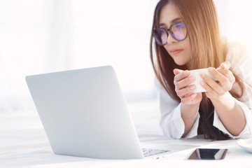 Portrait of a young business woman ,laptop,cup of coffee. Business concept a laptop drinking coffee with her computer on the bed