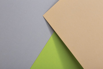 Colored paper composition with nude, fresh green and gray paper, design elements