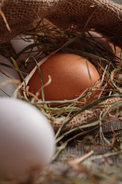 Rural eggs in jute bag with scattered hay around.