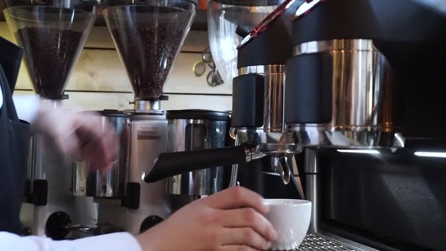 Barista making single cappuccino and steaming milk for late art