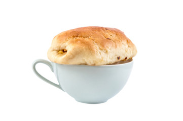 Fresh sweet bun on the cup of tea. Isolated on white.