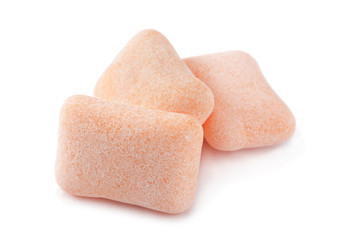 Peach color chewing gum piece on white