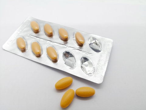 Medication concept. Brown tablet drug used for venous circulation disorder and for acute hemorrhoidal attack, that were removed from blister. Isolated on white background and copy space.