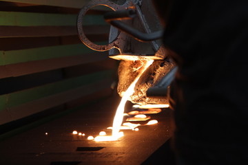 Iron molten metal pouring in sand mold ;