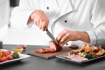 Chef slicing yummy honey baked ham on wooden board