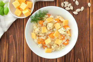 Dish with delicious pumpkin risotto on wooden table