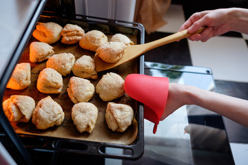housewife getting out of the oven prepeared baked cookies