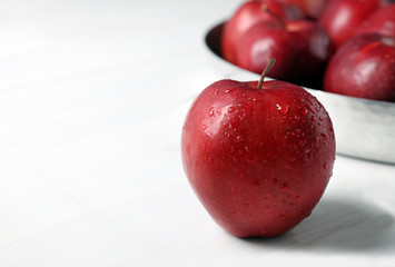Ripe red apple on white table