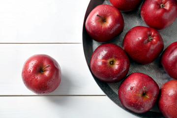 Plate with ripe red apples on table