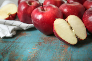 Ripe red apples on color wooden table, closeup