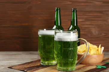 Glass of green beer on wooden board. Saint Patrick's day celebration