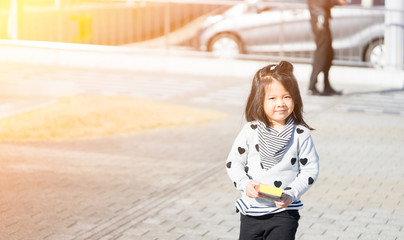 Funny little asian girl having fun and walking on street winter time in Japan .