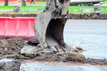 excavator removes road asphalt