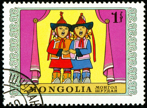 Ukraine - circa 2018: A postage stamp printed in Mongolia show two children in Mongolian national clothes sing. Series: International Childrens Day. Circa 1975.