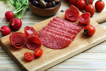antipasti salame su tagliere di legno sfondo tavolo di cucina © denio109