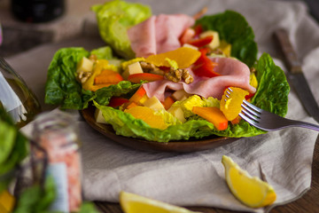 bowl of fresh salad with vegetables and greens on wooden table