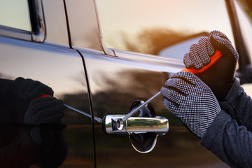 Thieves trying to open The car door.