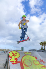 boy jumping at the skate park over a ramp