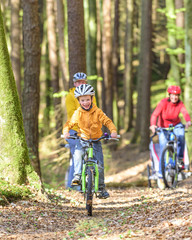fröhlicher Junge beim Radeln im Wald