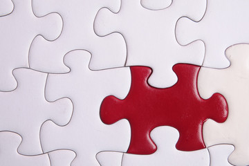 Fototapeta premium Red puzzle on white background. Copy space