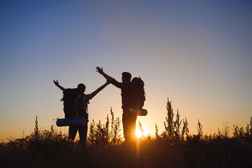 Silhouette of young couple against colorful sunset