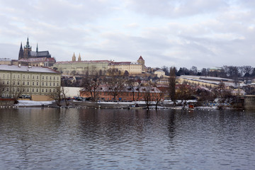 Fototapeta na wymiar Snowy Prague Lesser Town with gothic Castle above River Vltava, Czech republic
