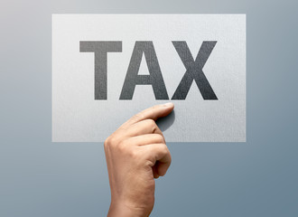 People hands holding white paper with TAX text