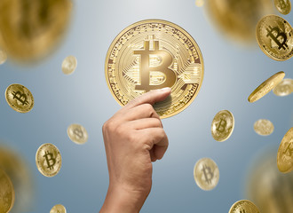 Plakat Man hands holding golden bitcoin with falling bitcoins