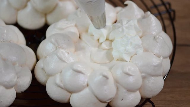 Decorate the cake Pavlova with cream
