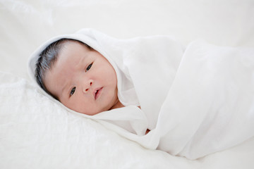 Lovely newborn Asian baby sleeping on furry blanket