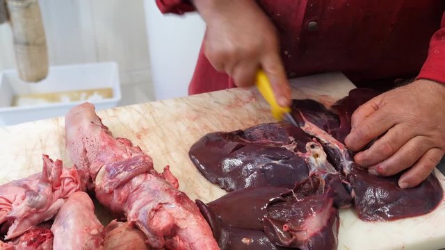 Butcher cuts liver on a table