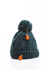 Knitted wool pom pom hat decorated with small orange baubles