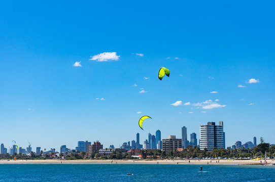 Picturesque urban cityscape with kite surfers on the beach