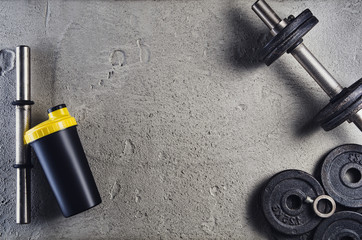 Fitness or bodybuilding concept background. Product photograph of old iron dumbbells on grey, conrete floor in the gym. Photograph taken from above, top view with lots of copy space