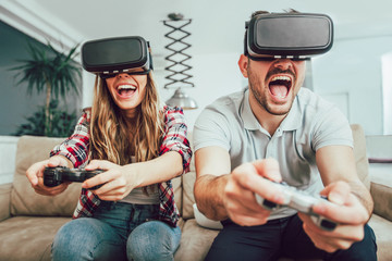 Young funny couple playing video games virtual reality glasses in their apartment © Mediteraneo