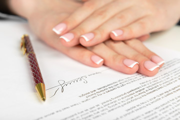 Obraz na płótnie Canvas Woman hand signing a contract