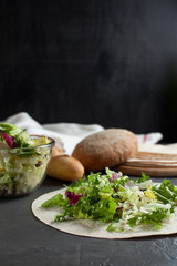 vegetarian lavash with fresh herbs and bread on a dark background