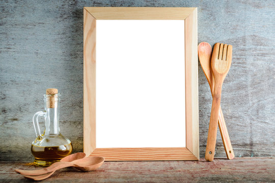 empty wooden frame with isolated white background and kitchen utensils on a wooden background