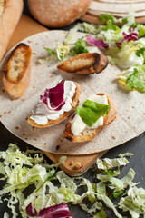 sandwiches with fresh herbs, sour cream and cheese and bread on a dark background