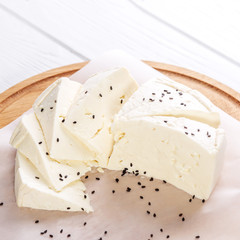 Feta cheese with sesame seeds. Top view. Square. The concept is healthy food, vegetarianism, farm.