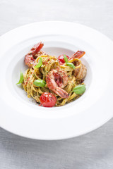 Traditional Italian tagliatelle ai gamberoni with tomatoes as close-up on a plate