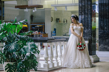 Fototapeta premium Portrait of a beautiful young young bride. Beautiful bride with wedding make-up and decoration wreath for long black hair.
