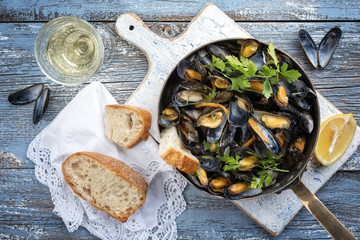 Traditional barbecue Italian blue mussel in white wine as top view in a casserole