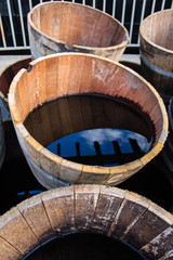 Old half barrels filled with water reflecting the surroundings.